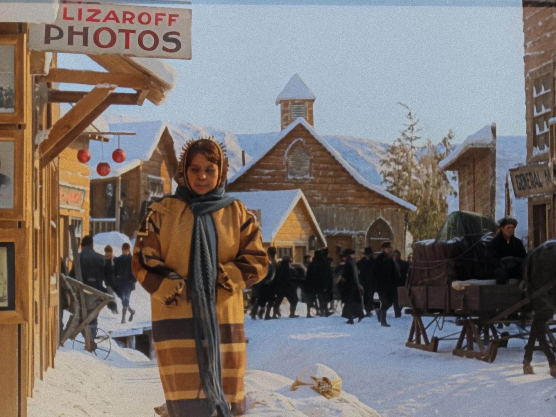 Colourised archive film still of a woman in a snowy town street